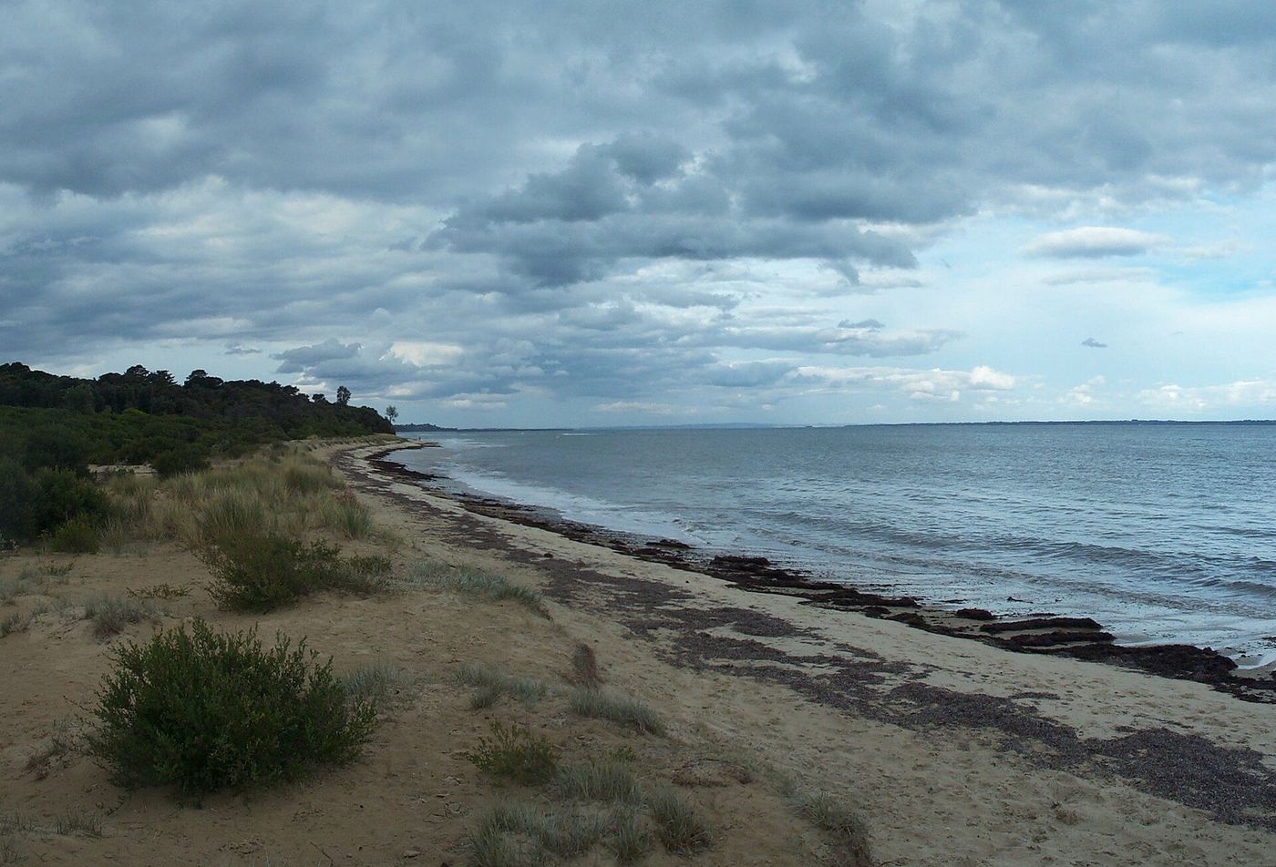 Merricks Beach on an overcast day, with a narrow strip of sand